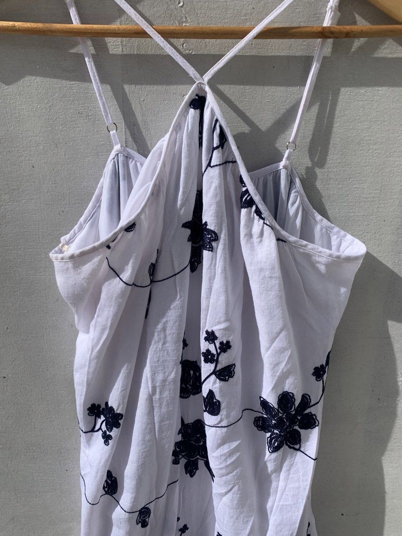 white halter dress with embroidery (Category: Dresses) located in Muntinlupa City. Submitted by pink.poppies (Listing ID 1468767216, Image 2). Description: - Color & Design: White dress with chic black floral embroidery - Fit & Style: Halter neck with thin adjustable crossover straps - Fabric: Lightweight and flowy material for maximum comfort - Versatility: Ideal as a beach cover-up or casual summer outfit - Condition: Clean, easy to slip on, an