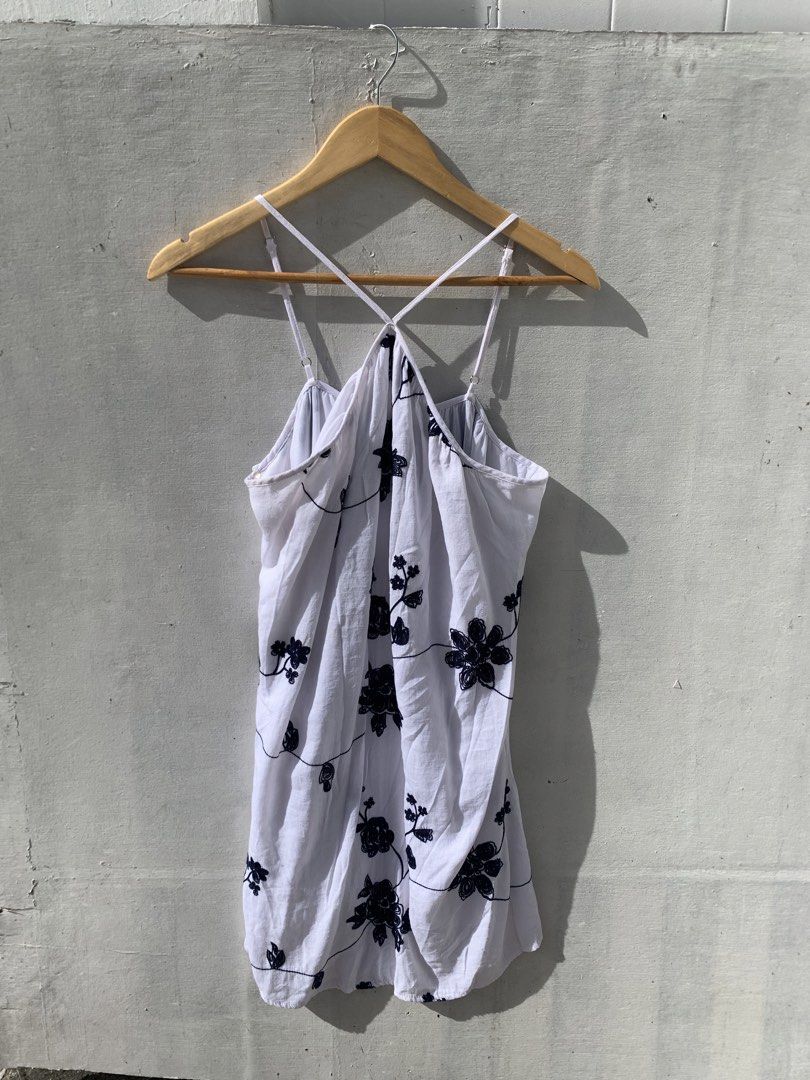 white halter dress with embroidery (Category: Dresses) located in Muntinlupa City. Submitted by pink.poppies (Listing ID 1468767216, Image 1). Description: - Color & Design: White dress with chic black floral embroidery - Fit & Style: Halter neck with thin adjustable crossover straps - Fabric: Lightweight and flowy material for maximum comfort - Versatility: Ideal as a beach cover-up or casual summer outfit - Condition: Clean, easy to slip on, an