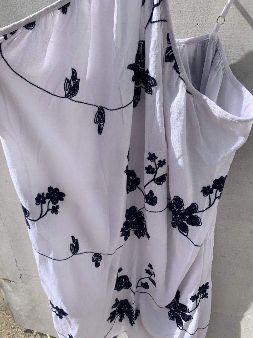 white halter dress with embroidery (Category: Dresses) located in Muntinlupa City. Submitted by pink.poppies (Listing ID 1468767216, Image 3). Description: - Color & Design: White dress with chic black floral embroidery - Fit & Style: Halter neck with thin adjustable crossover straps - Fabric: Lightweight and flowy material for maximum comfort - Versatility: Ideal as a beach cover-up or casual summer outfit - Condition: Clean, easy to slip on, an