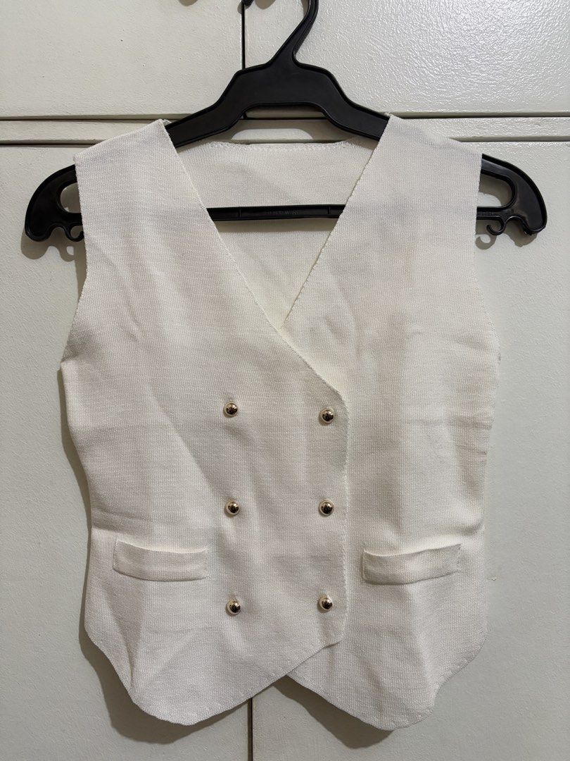 White Knit Double-Breasted Vest with Gold Buttons (Category: Sleeveless) located in Bulacan. Submitted by hey_alyyy (Listing ID 1468715614, Image 1). Description: - Style: White knit vest with a chic double-breasted front - Details: Six round gold-tone buttons in two rows, V-neckline, and unique asymmetric hem - Pockets: Two functional front slip pockets near the hem - Fabric: Lightweight, clean finish, and comfortable to wear - Condition: Excell