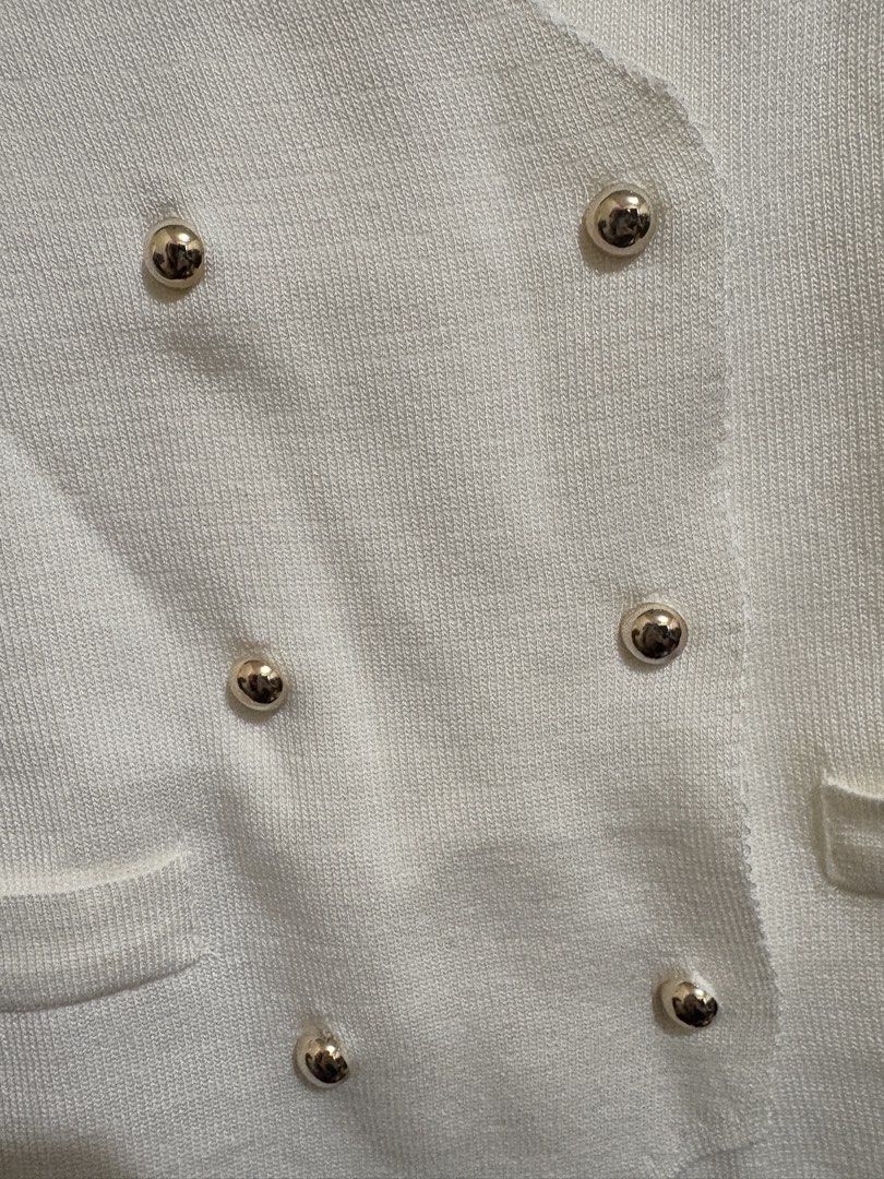White Knit Double-Breasted Vest with Gold Buttons (Category: Sleeveless) located in Bulacan. Submitted by hey_alyyy (Listing ID 1468715614, Image 2). Description: - Style: White knit vest with a chic double-breasted front - Details: Six round gold-tone buttons in two rows, V-neckline, and unique asymmetric hem - Pockets: Two functional front slip pockets near the hem - Fabric: Lightweight, clean finish, and comfortable to wear - Condition: Excell