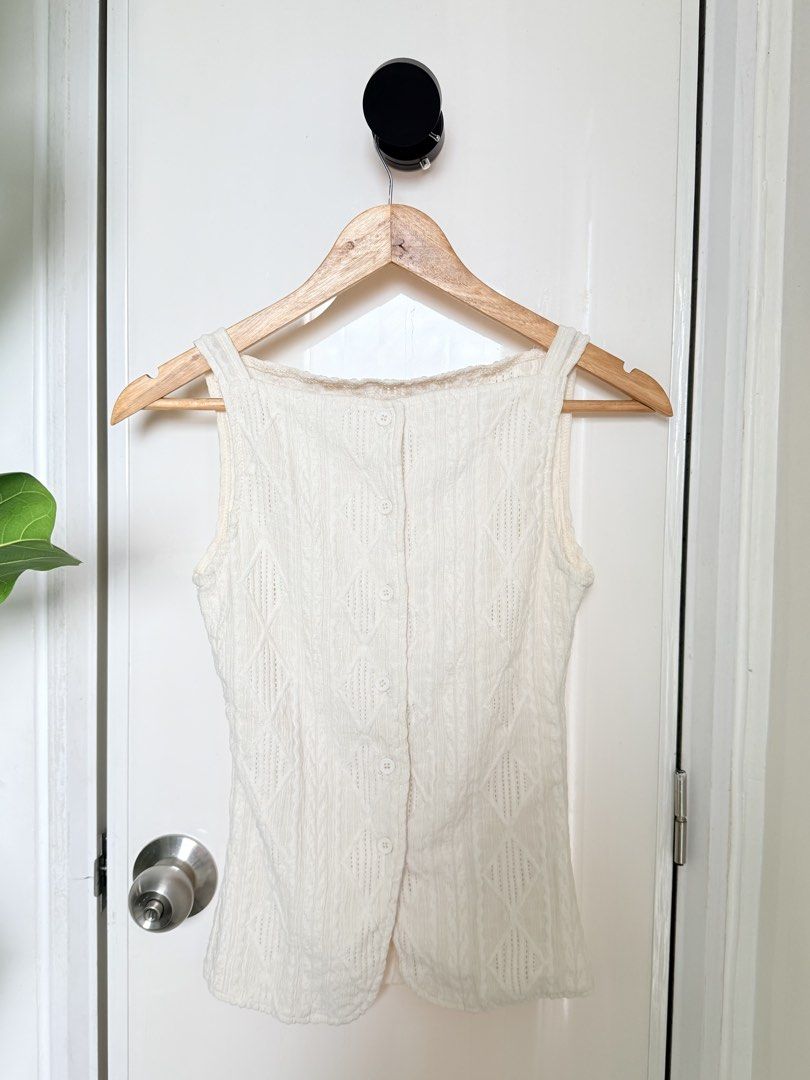 White Knitted Tank Top with Buttons (Category: Sleeveless) located in Quezon City. Submitted by ynnapenyaranda (Listing ID 1468870196, Image 2). Description: - Color: White - Style: Sleeveless knitted top with slim fit - Details: Textured diamond pattern, front button closure, square neckline - Versatile: Easy to pair with high-waisted jeans or skirts; great for layering - Condition: Brand new / Excellent quality.