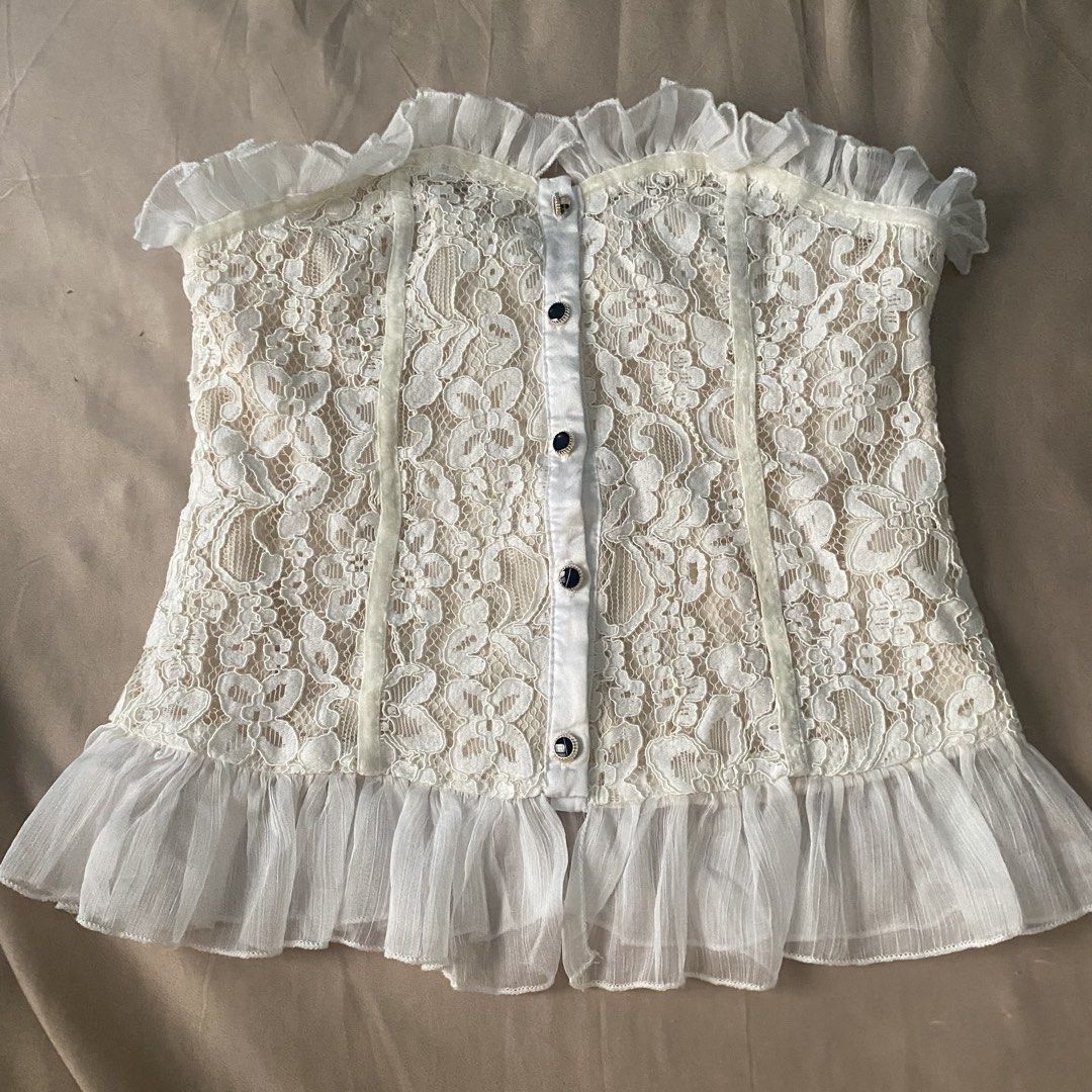 White Lace Corset Style Strapless Top with Ruffles (Category: Sleeveless) located in Manila. Submitted by rumyewn (Listing ID 1468807914, Image 1). Description: - Color/Design: White with floral lace overlay and nude lining - Closure: Front button-up with dark metallic buttons - Details: Ruffled trim on top edge and hem, front boning channels for structure - Fit: Strapless, lightweight, pairs great with high-waist jeans or skirts - Condition: Exc