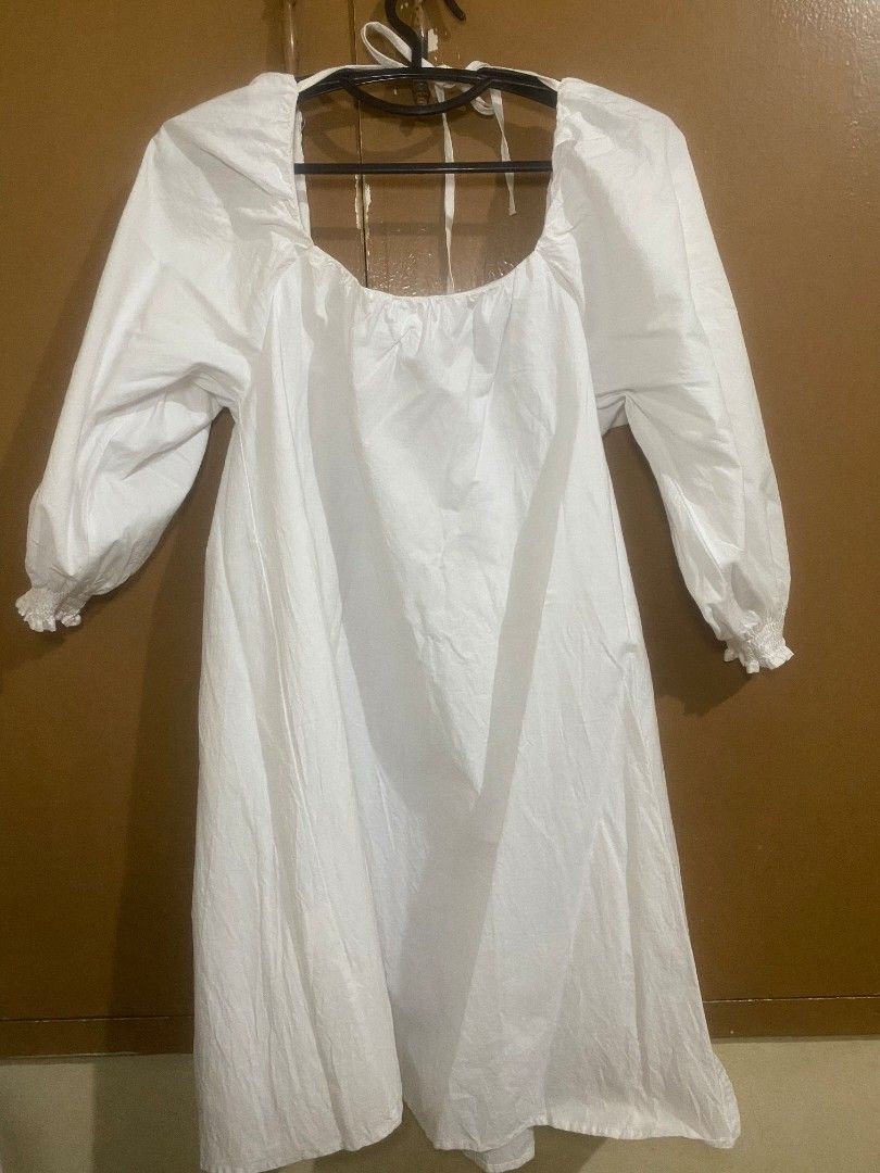 White long sleeve dress with tie back (Category: Dresses) located in Muntinlupa City. Submitted by swiftowl.0cc8ab (Listing ID 1468854389, Image 3). Description: - Color: White - Design: Square neckline with adjustable back tie strings - Sleeves: Long puffy sleeves with comfortable elastic cuffs - Fabric: Soft, lightweight, and flowy cotton-like material - Versatility: Perfect basic piece for casual outings, dates, and easily dressed up or down.
