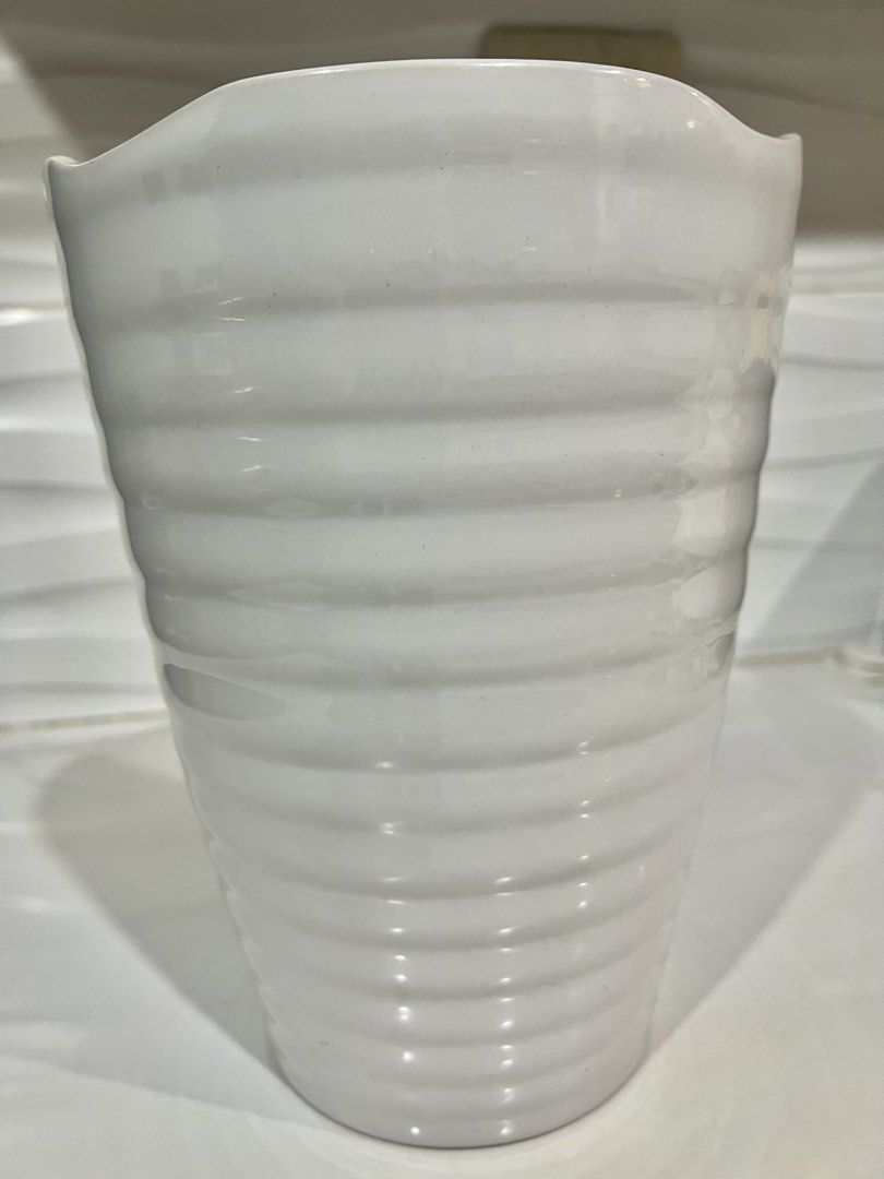 White Ribbed Ceramic Flower Vase (Category: Vases & Decorative Bowls) located in Pateros City. Submitted by mcacompany (Listing ID 1468888290, Image 2). Description: - Material: White ceramic with a glossy finish - Design: Horizontal ribbed texture and unique wavy rim - Shape: Tapered cylindrical silhouette - Versatile: Looks great with any flowers or displayed on its own - Perfect for living rooms, bedrooms, or tabletops Find many great new & us