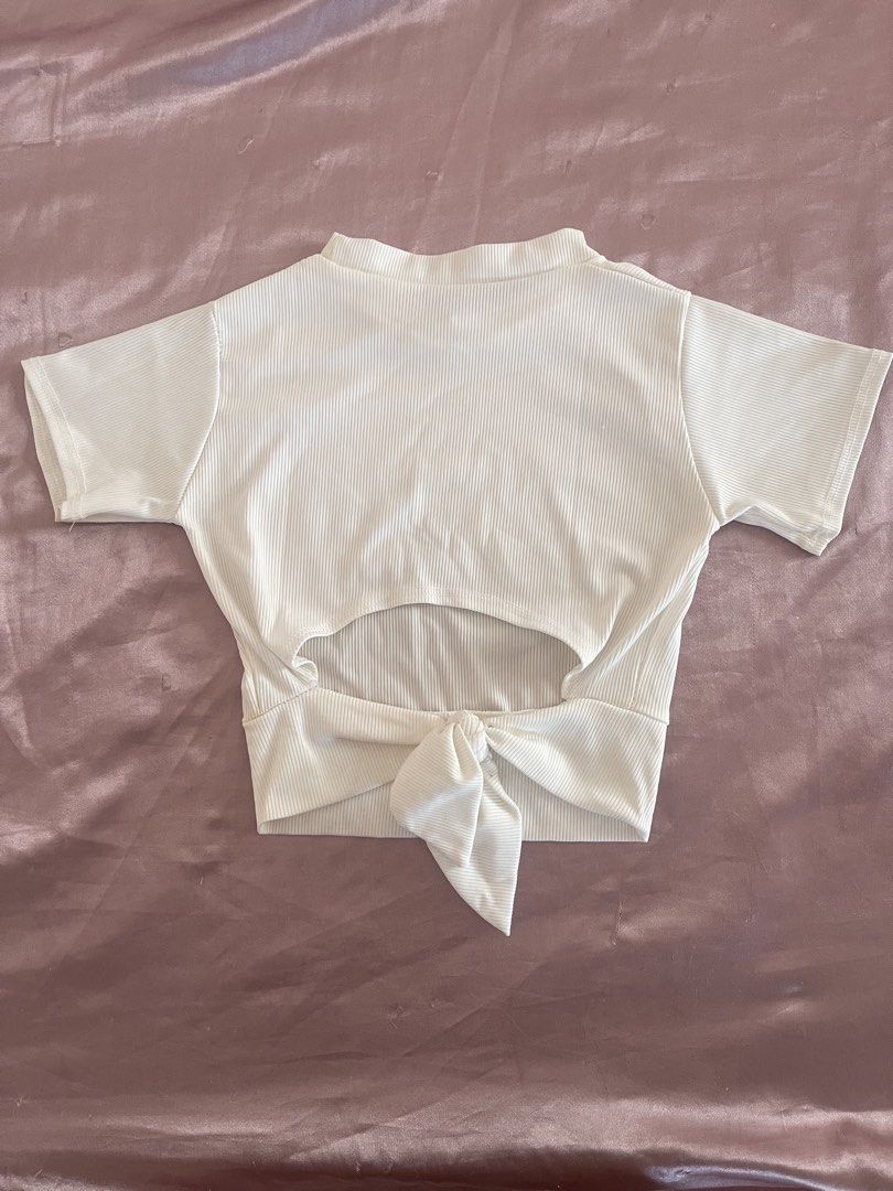 White Ribbed Knit Short Sleeve Open Back Crop Top (Category: Shirts) located in Manila. Submitted by lovedbymidge (Listing ID 1468869893, Image 2). Description: 🩷 for xs-s girlies (worn twice, in good condition) 🚚 lalamove or grab express (sf shouldered by the buyer!) - Color/Pattern: Solid white - Material: Stretchy ribbed knit, super comfortable - Design: Short sleeves, round neckline, open back cutout with tie-bow detail.