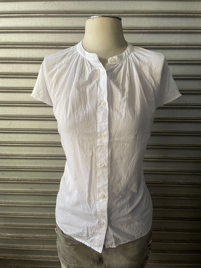 White Short Sleeve Button-Up Blouse (Category: Blouses) located in Davao. Submitted by riab_qt (Listing ID 1468777637, Image 2). Description: - Color: Crisp white - Size: M-L - Design: Mandarin collar, button-down front, and subtle gathered pleats - Fabric: Lightweight checkered textured material - Style: Versatile basic staple, great with skirts or trousers for casual or smart-casual looks.