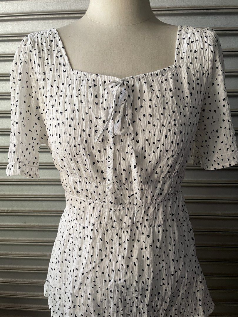 White Square Neck Blouse with Black Hearts (Category: Blouses) located in Davao. Submitted by riab_qt (Listing ID 1468775820, Image 3). Description: White short sleeve blouse with small black heart pattern all over. Square neckline with a tie ribbon detail in the front. Smocked, textured fabric from top to hem. Short puffed sleeves with elastic cuffs. Fitted bodice that flares slightly at the waist. Great casual piece, easy to match with skirts o