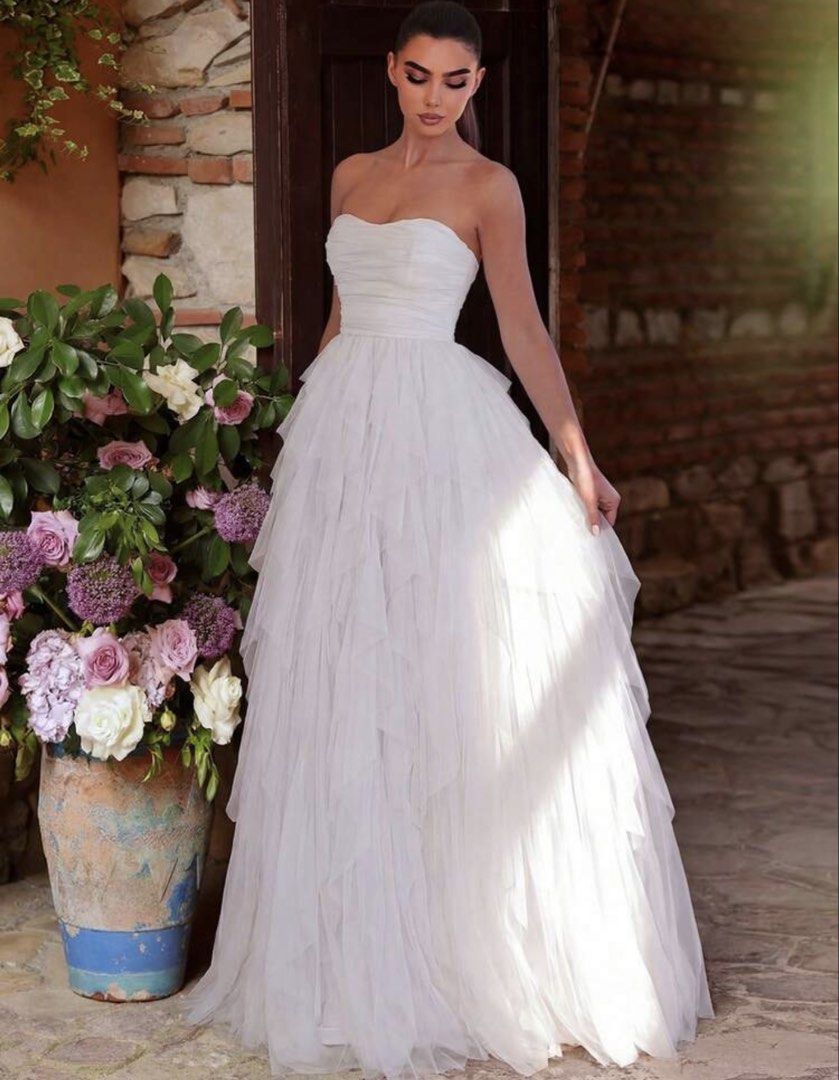 White Strapless Ruffled Tulle Wedding Gown (Category: Evening dresses & gowns) located in Santo Tomas. Submitted by kylejao21 (Listing ID 1468875874, Image 1). Description: - Color: White - Style: Strapless, straight neckline with a fitted ruched bodice - Skirt: Flared multilayer tulle with soft, floor-length ruffles - Fabric: Lightweight and comfortable - Condition: Worn once for a photoshoot, dry-cleaned immediately, like new (no stains or tear