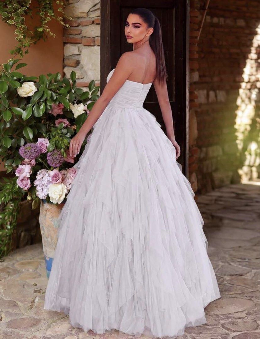 White Strapless Ruffled Tulle Wedding Gown (Category: Evening dresses & gowns) located in Santo Tomas. Submitted by kylejao21 (Listing ID 1468875874, Image 2). Description: - Color: White - Style: Strapless, straight neckline with a fitted ruched bodice - Skirt: Flared multilayer tulle with soft, floor-length ruffles - Fabric: Lightweight and comfortable - Condition: Worn once for a photoshoot, dry-cleaned immediately, like new (no stains or tear