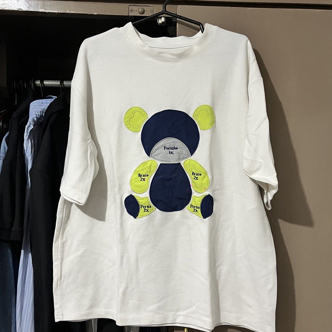 White T-Shirt with Abstract Teddy Bear Graphic (Category: Shirts) located in Manila. Submitted by kimsunnycart (Listing ID 1468837028, Image 1). Description: - Color: Clean white - Fit: Relaxed, comfortable fit - Material: Thick, high-quality ribbed fabric - Design: Fun abstract bear graphic with Portuguese anatomical labels (Braco, Perna) - Styling: Perfect for casual days out with jeans or shorts.