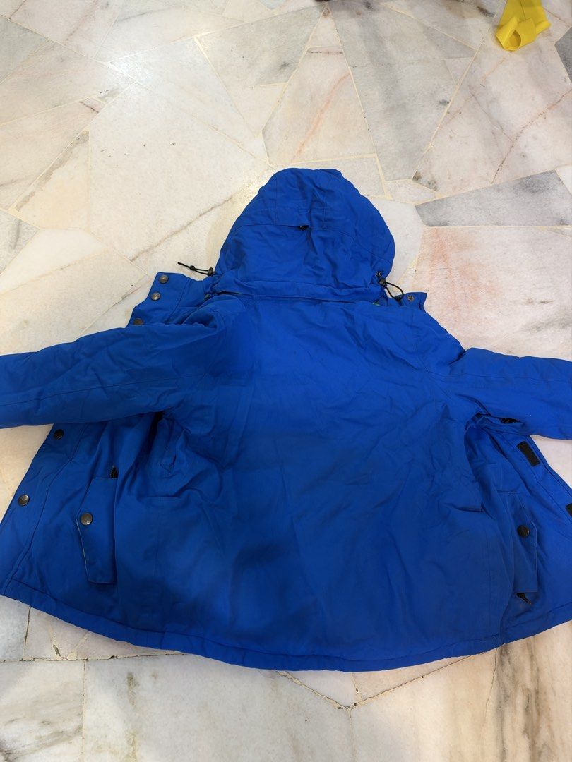 Winter Jacket (Category: Coats, Jackets and Outerwear) located in Kuala Lumpur. Submitted by zacchchan_166 (Listing ID 1468857913, Image 3). Description: - Color: Bright blue with vibrant green and blue geometric hood/inner lining - Closure: Full zip front with button flap cover - Features: Multiple front pockets, adjustable hooded design with drawstrings - Lining: Warm quilted black inner lining - Ideal for: Cold weather travel, winter sports, a