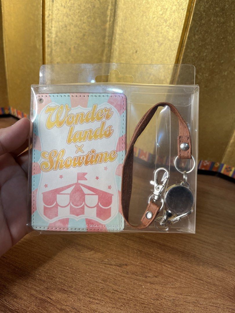 Wonderlands x Showtime ID Card Case / Pass Case Project Sekai (Category: Wallets & Card holders) located in Gapan. Submitted by lunashop14 (Listing ID 1468716542, Image 1). Description: 2 pcs available sealed - Official SEGA Project Sekai merchandise - Wonderlands x Showtime circus-themed design with pastel stripes - Includes brown leatherette card holder, matching strap, and retractable reel - Brand new and still inside original plastic packagin