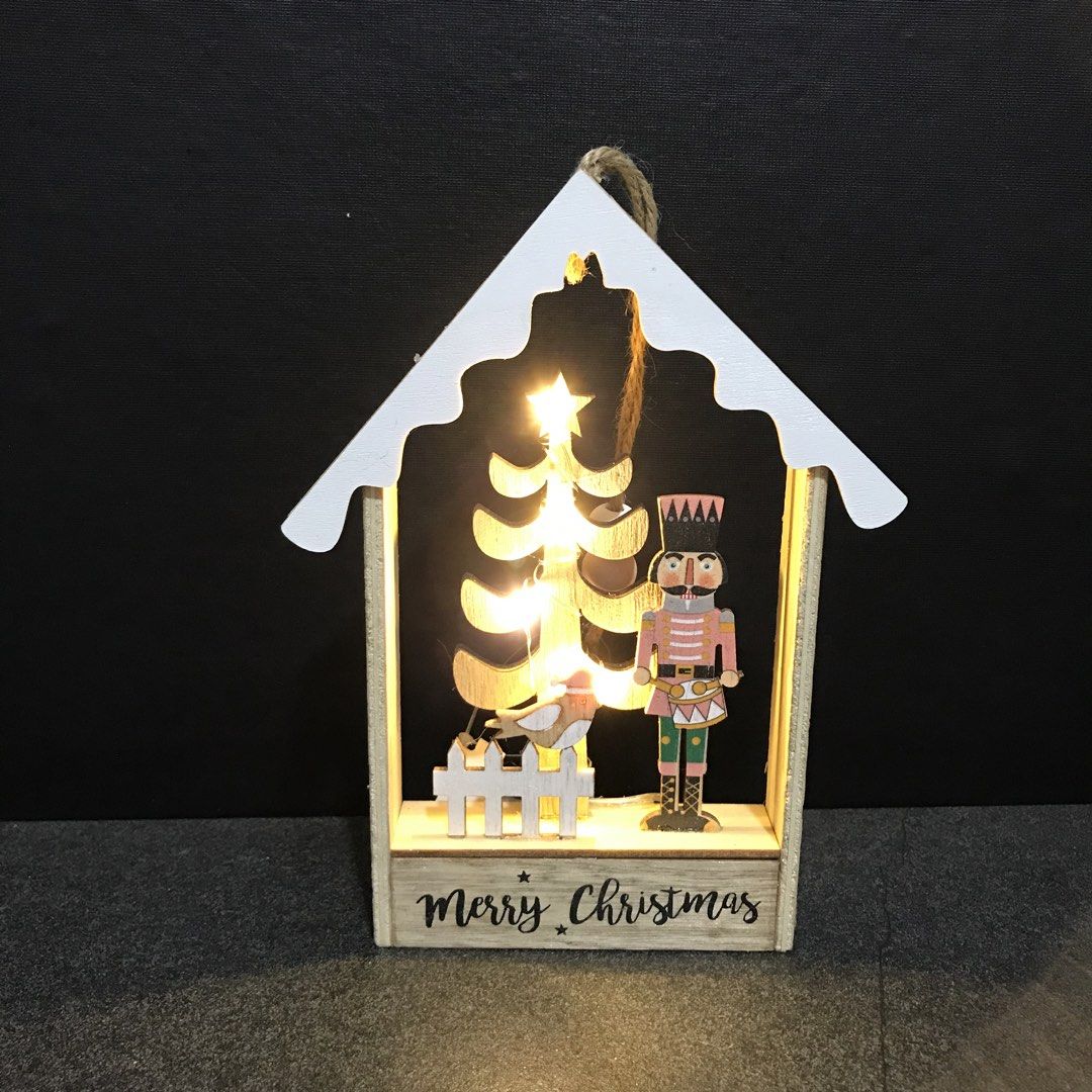 Wooden Christmas House LED Light Nutcracker Tree Decor (Category: Wall Decor) located in Baao. Submitted by all.things.japan (Listing ID 1468753328, Image 2). Description: 7.25 x 5.5 x 1.0 inches - Wooden house-shaped Christmas decor with built-in warm fairy lights - Detailed interior scene featuring a nutcracker soldier, miniature tree, bird, and picket fence - Features a cheerful 'Merry Christmas' greeting on the base - Natural wood frame accen