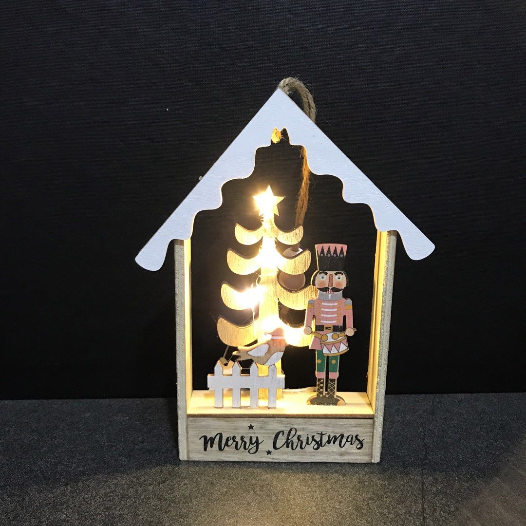 Wooden Christmas House LED Light Nutcracker Tree Decor (Category: Wall Decor) located in Baao. Submitted by all.things.japan (Listing ID 1468753328, Image 1). Description: 7.25 x 5.5 x 1.0 inches - Wooden house-shaped Christmas decor with built-in warm fairy lights - Detailed interior scene featuring a nutcracker soldier, miniature tree, bird, and picket fence - Features a cheerful 'Merry Christmas' greeting on the base - Natural wood frame accen