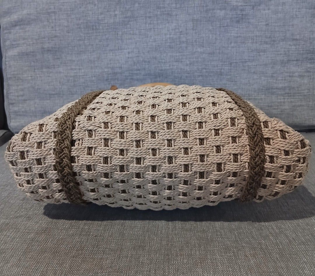 Woven Straw Tote Bag with Bamboo Handles (Category: Beach Bags) located in Alaminos. Submitted by sachiKaSan (Listing ID 1468855729, Image 3). Description: - Style: Beige woven rattan tote with brown braided stripe accents - Handles: Stylish wooden bamboo handles attached with bronze-tone metal rings - Interior: Fabric-lined with a convenient zippered side pocket - Closure: Secure magnetic snap closure - Perfect for: Everyday use, beach trips, an