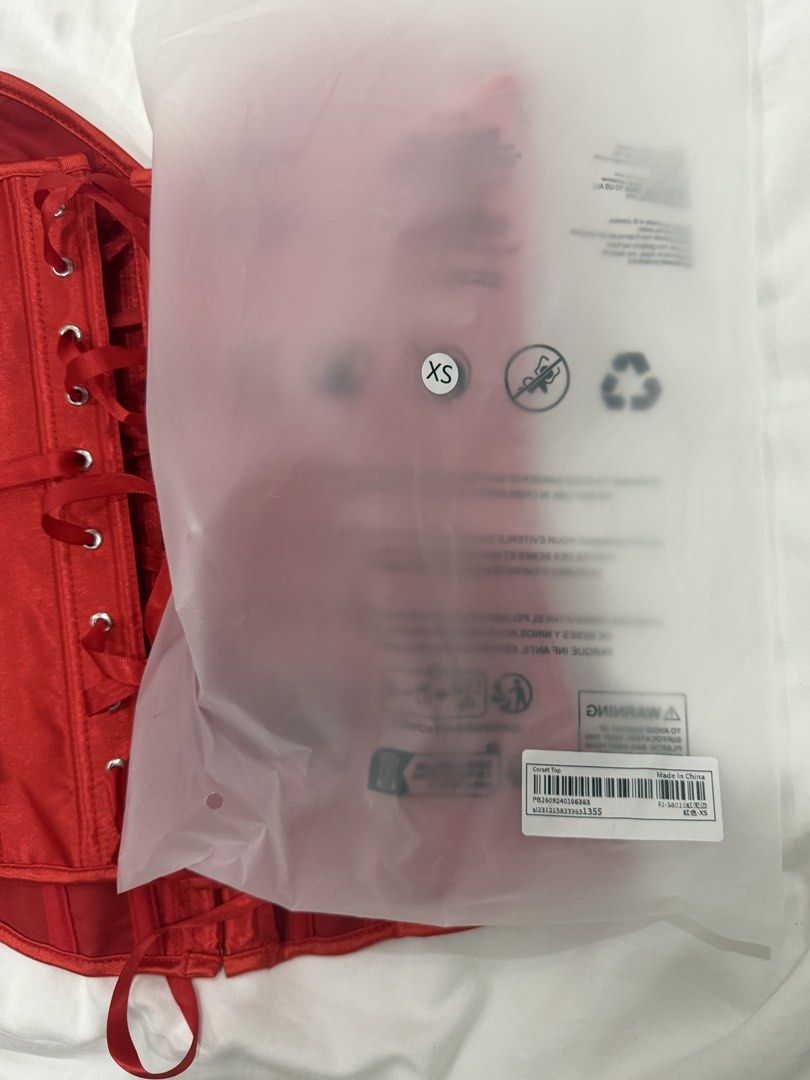 XS - Red Satin Corset Top (Category: Sleeveless) located in Manila. Submitted by calmcloud-ff9802 (Listing ID 1468876578, Image 3). Description: - Condition: Brand new, still sealed in original packaging with barcode label - Size: XS - Material: Vibrant red satin with structured boning throughout - Closure: Front metal hook busk closure - Fit: Adjustable back lace-up ribbon system - RFS: I liked my backup customer better for halloween .
