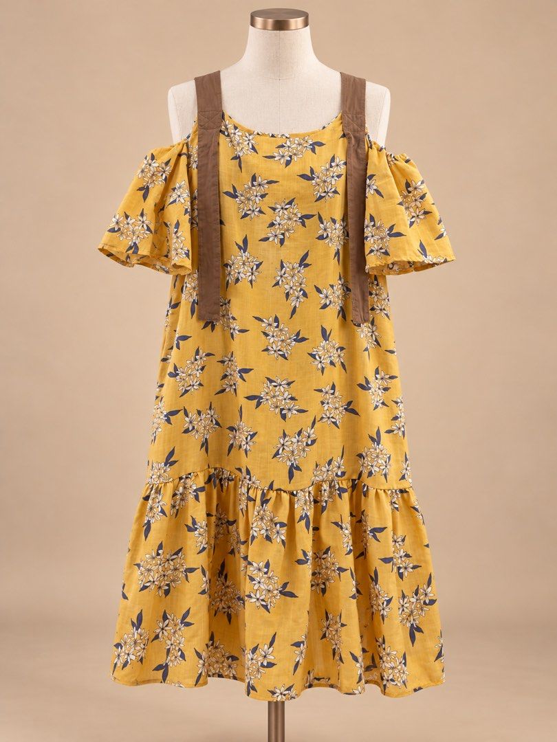 Yellow Floral Cold Shoulder Dress (Category: Dresses) located in Caloocan City. Submitted by joannarms320722 (Listing ID 1468780073, Image 1). Description: - Style: Bright yellow midi dress with white and blue floral print - Design: Cold shoulder cut with ruffled short sleeves and decorative hanging brown straps - Details: Ruffled hem tier at the bottom and lightweight fabric - Fit: Loose, relaxed, and easy slip-on style - Condition: Brand new / 