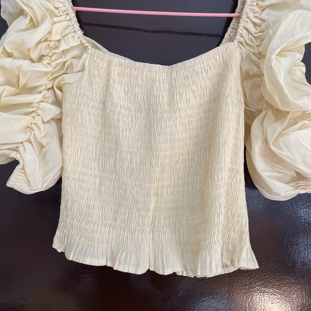 Yellow smocked puff sleeve top (Category: Blouses) located in Pasay City. Submitted by lovedbyzea (Listing ID 1468785040, Image 2). Description: - with fre dot stains, needs wash - Colour: Cream - Style: Crop top with square neckline and frilly hem - Fit: Super stretchy smocked bodice, easy to slip on and off - Details: Dramatic puff sleeves with ruching and ruffles - Pairing: Looks great with high-waisted jeans or skirts - Condition: Worn a few 