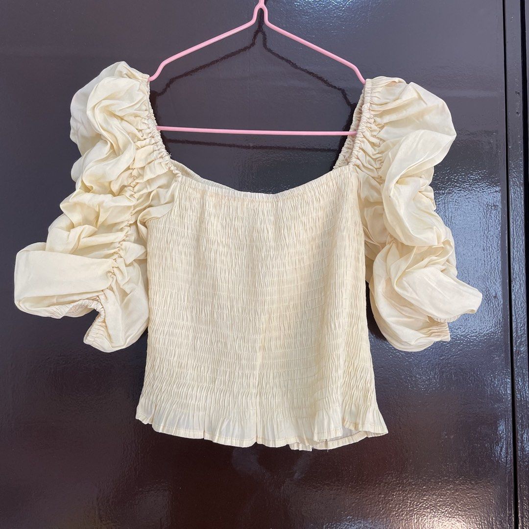 Yellow smocked puff sleeve top (Category: Blouses) located in Pasay City. Submitted by lovedbyzea (Listing ID 1468785040, Image 1). Description: - with fre dot stains, needs wash - Colour: Cream - Style: Crop top with square neckline and frilly hem - Fit: Super stretchy smocked bodice, easy to slip on and off - Details: Dramatic puff sleeves with ruching and ruffles - Pairing: Looks great with high-waisted jeans or skirts - Condition: Worn a few 