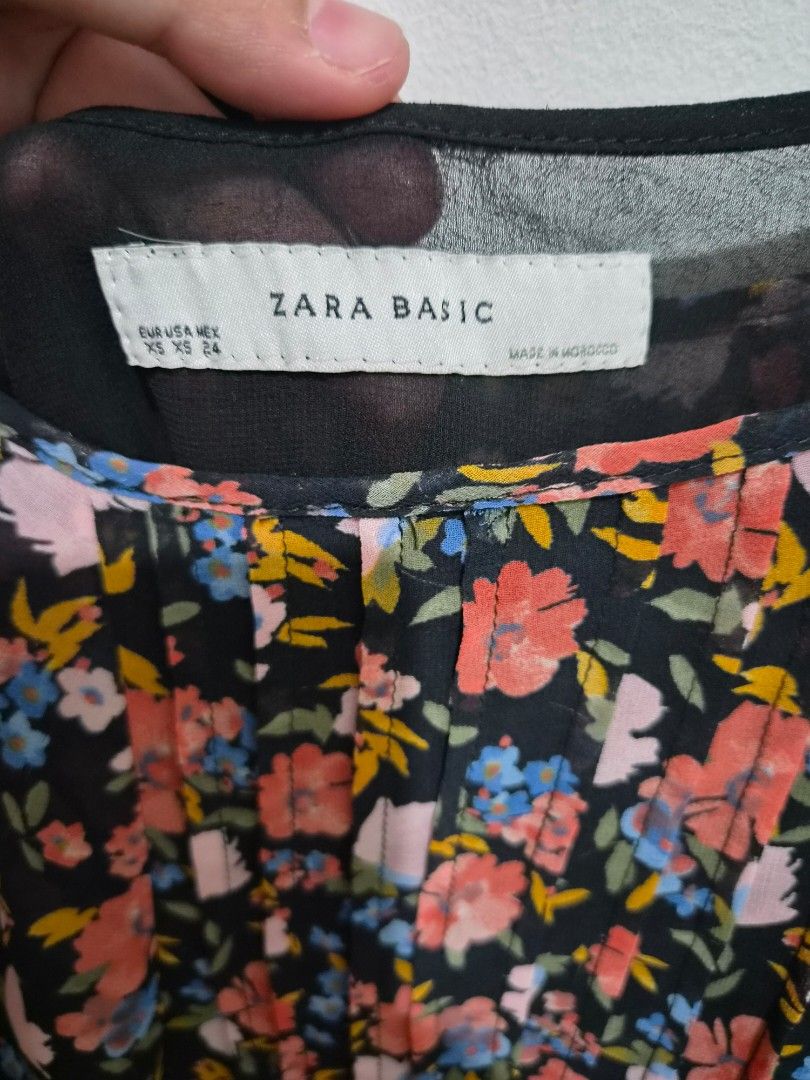Zara Basic Floral Print Spaghetti Strap Tank Top (Category: Sleeveless) located in Calamba. Submitted by junelbaliwag (Listing ID 1468879557, Image 2). Description: - Brand: Zara Basic - Style: Tank top with thin spaghetti straps, pleated front, and gathered hem - Design: Black base with a vibrant multi-color floral print (pink, blue, yellow) - Material: Lightweight chiffon-like fabric with full inner lining - Origin: Made in Morocco - Size: XS (