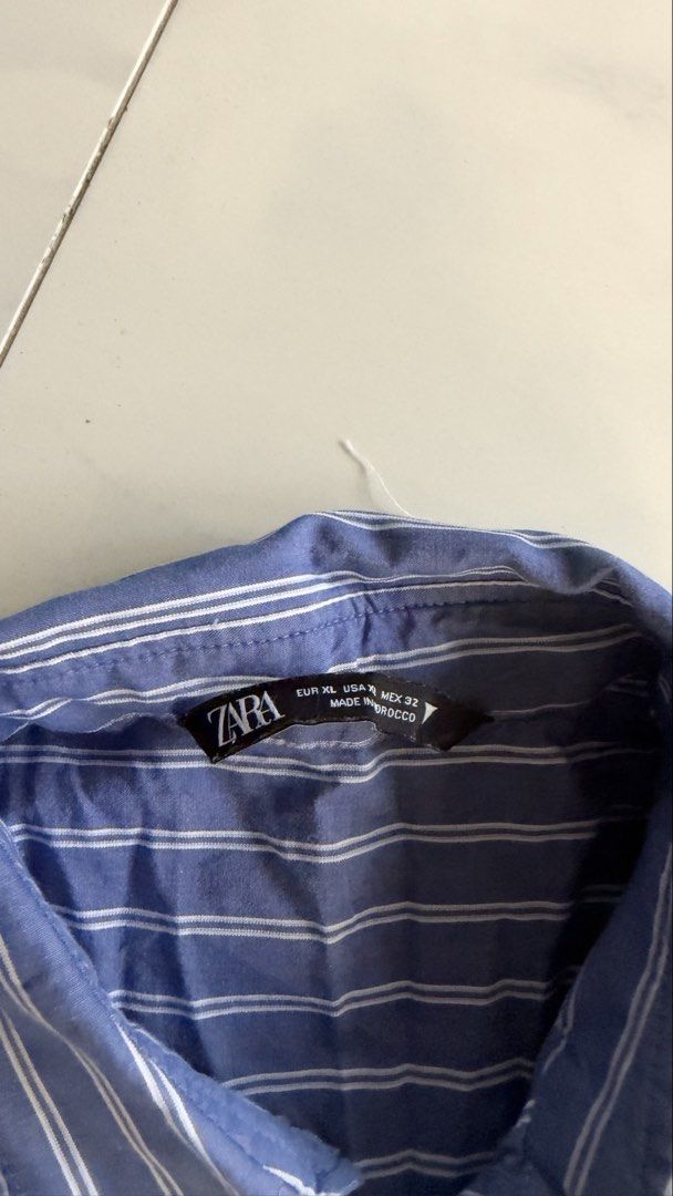 Zara Blue Striped Oversized Button Down Polo (Category: Longsleeves) located in Manila. Submitted by patc20 (Listing ID 1468792165, Image 3). Description: - Brand: Zara - Style: Blue and white striped button-down shirt with oversized fit - Size: XL - Details: Contrasting white layered hem, white collar trim, and left chest pocket - Origin: Made in Morocco.
