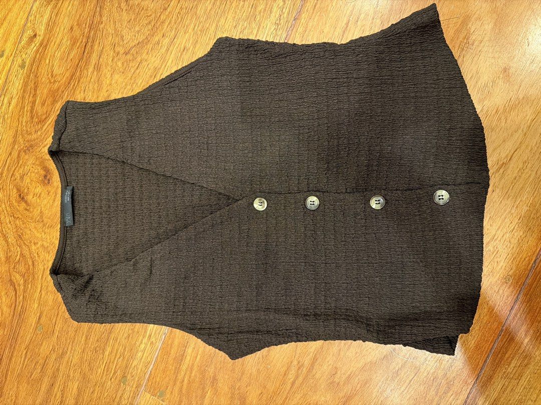 Zara Brown Textured V-Neck Button-Up Vest (Category: Sleeveless) located in Quezon City. Submitted by nic.man (Listing ID 1468861097, Image 1). Description: - Brand: Zara - Color: Dark brown - Fabric: Crinkled textured material - Neckline: V-neck with front button closure - Details: 4 tortoise-shell patterned front buttons, sleeveless - Fit: Tagged size inside collar.