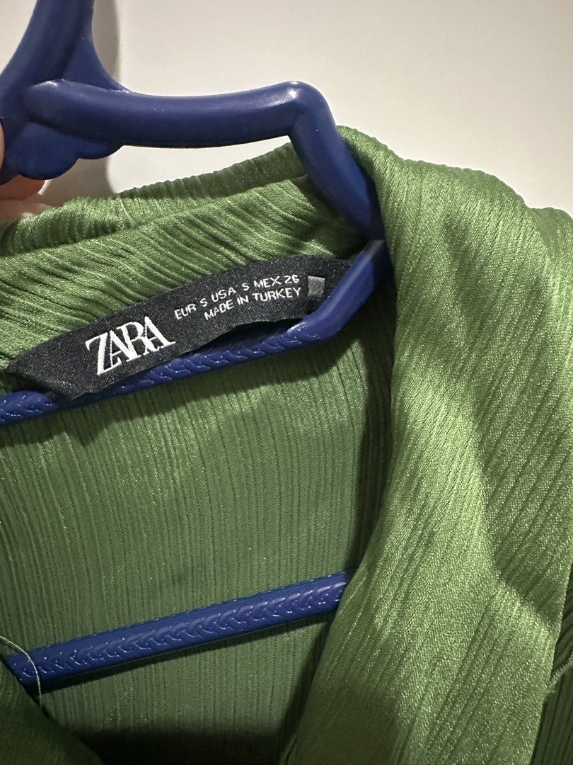 Zara Green Ruffle Collar Blouse Size S (Category: Blouses) located in Taguig. Submitted by ellajanee (Listing ID 1468766387, Image 3). Description: - Brand: Zara - Size: S - Made in Turkey - Color: Green - Design: Button-up front with sparkly crystal buttons - Details: Oversized ruffle collar with matching neckline tie and textured fabric throughout - Sleeves: Long sleeves with button cuffs - Versatility: Perfect for office wear or dressing up fo