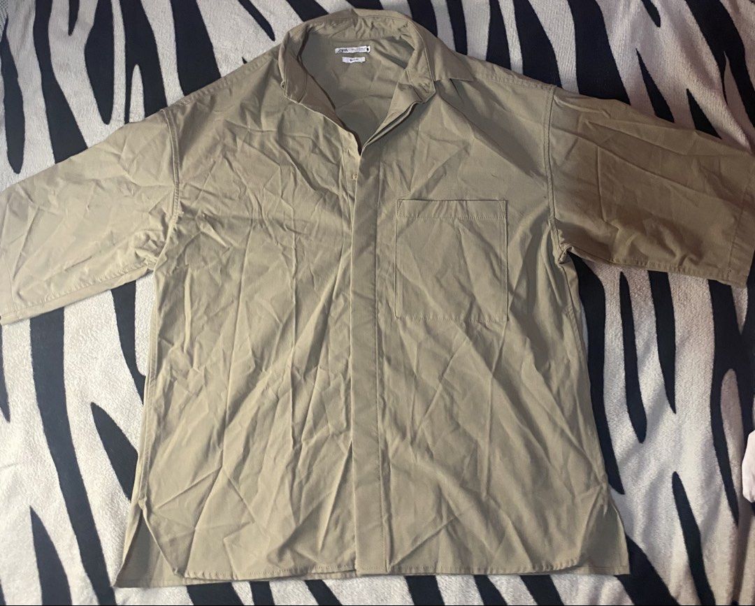 Zara Oversized Button-Down Shirt khaki (Category: Activewear) located in Manila. Submitted by ddxyatchang (Listing ID 1468834004, Image 1). Description: FOR SALE: Zara Oversized Button-Down Shirt - Khaki - Brand: Zara - LEGIT / Authentic - Size S on tag FITS M to XL Oversized (25-26W x 27L) - Color: Khaki Beige - aesthetic / neutral - Fabric: Poly + Viscose + Elastane - stretchy & comfy - Style: Boxy fit, drop shoulder, front pocket - Condition: 