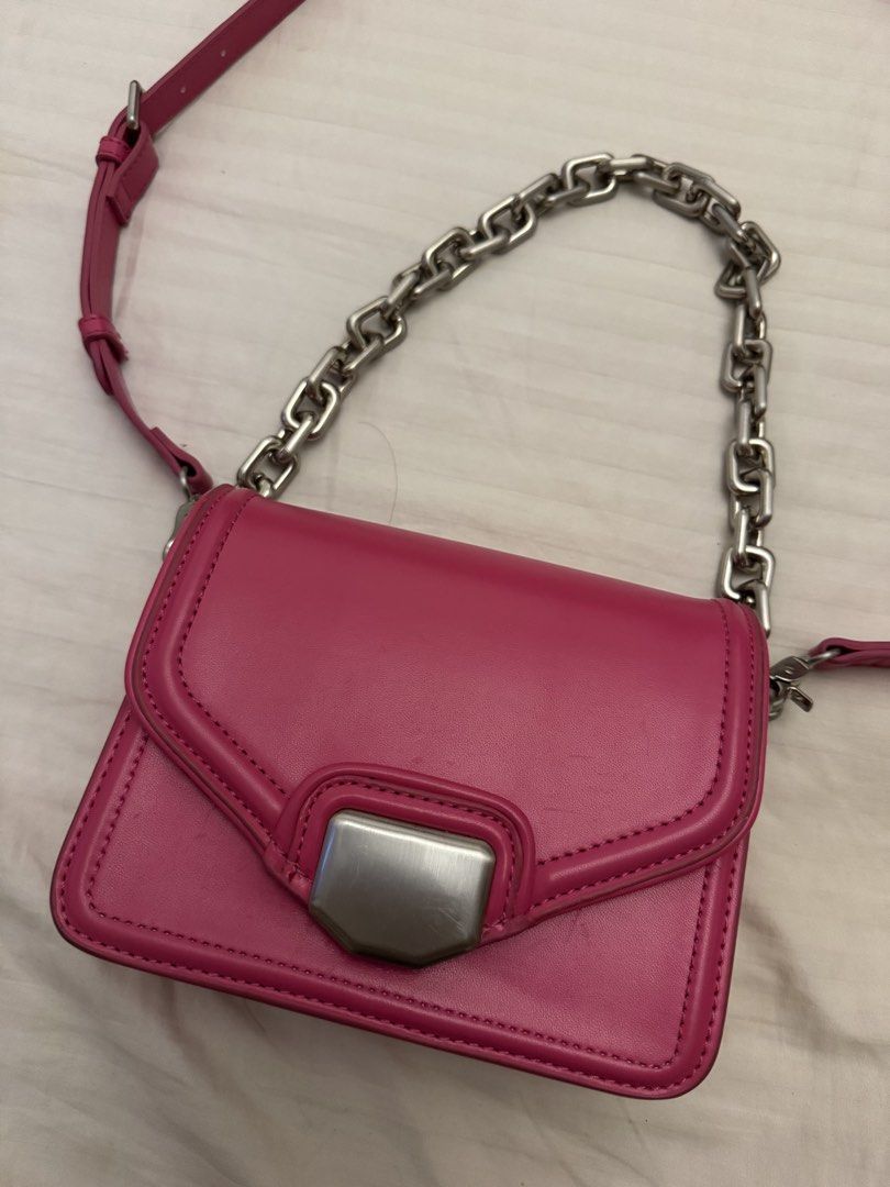 Zara Pink Crossbody Bag With Chain Strap (Category: Cross-body Bags) located in Marikina City. Submitted by kaceinpoint (Listing ID 1468803716, Image 2). Description: - Brand: Zara - Color: Bright pink - Closure: Secure magnetic front flap - Straps: Chunky silver chain handle and an adjustable matching pink shoulder strap - Interior: Black fabric lining with Zara logo tag and product care tag - Condition: Clean interior and exterior.