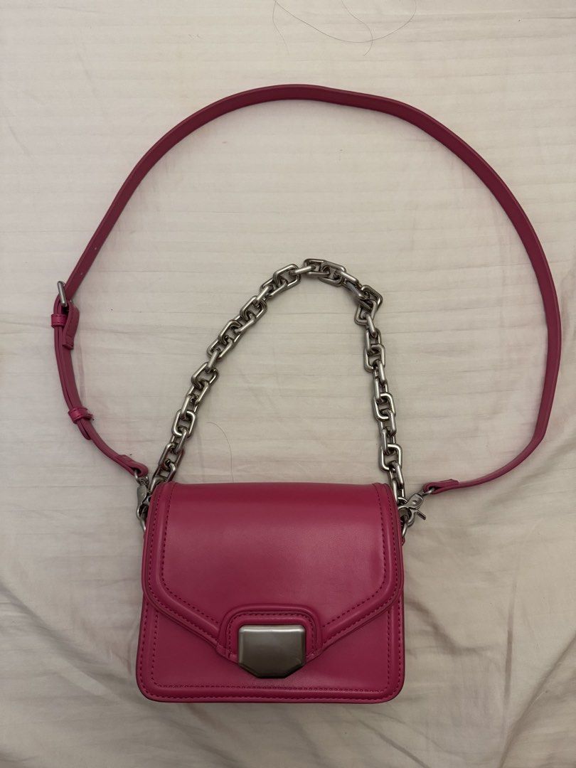 Zara Pink Crossbody Bag With Chain Strap (Category: Cross-body Bags) located in Marikina City. Submitted by kaceinpoint (Listing ID 1468803716, Image 1). Description: - Brand: Zara - Color: Bright pink - Closure: Secure magnetic front flap - Straps: Chunky silver chain handle and an adjustable matching pink shoulder strap - Interior: Black fabric lining with Zara logo tag and product care tag - Condition: Clean interior and exterior.