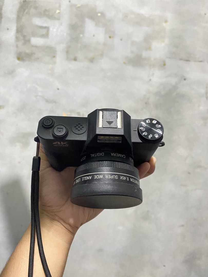 4K Ultra HD Digital Camera with Wide Angle Lens (Category: Cameras) located in General Santos City (Dadiangas). Submitted by jedlmaed54504 (Listing ID 1469014667, Image 3). Description: - 4K Ultra HD digital camera in sleek black - Equipped with a 0.45x super wide-angle lens and lens cap - Convenient built-in flash and top mode dial for easy adjustments - Side ports include microphone, USB, and memory card slot - Includes a secure wrist strap for