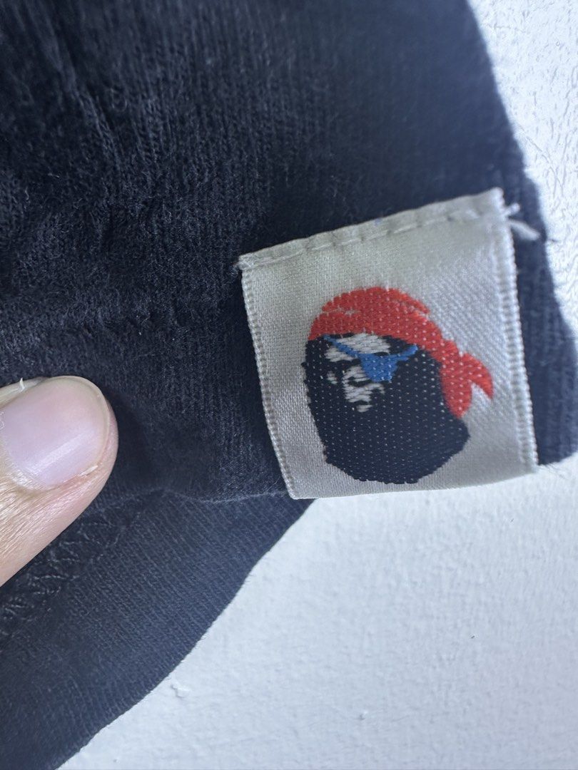 A Bathing Ape Bape Black Skull Graphic Tee Size L (Category: Tshirts & Polo Shirts ) located in Manila. Submitted by declutterpromax (Listing ID 1468995822, Image 2). Description: - Brand: A Bathing Ape (Bape) - Color: Black - Size: Large (Measures 20" x 27" inches) - Design: White skull graphic on chest with text - Details: Pirate motif sleeve tag, green camo inside neck tag - Condition: 100% authentic, well-maintained - Mode of Payment & Shippi