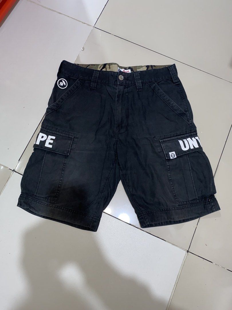 AAPE By A Bathing Ape Black Cargo Shorts Size M (Category: Shorts) located in Manila. Submitted by japhetcond32104 (Listing ID 1469111602, Image 1). Description: - Brand: AAPE by A Bathing Ape - Size: Medium - Color: Black with camo print inner waistband lining - Details: White letter print on side pockets and logo-embossed button closure - Storage: Multiple utility pockets with brand tags - Origin: Made in China - Condition: Shows regular wash w