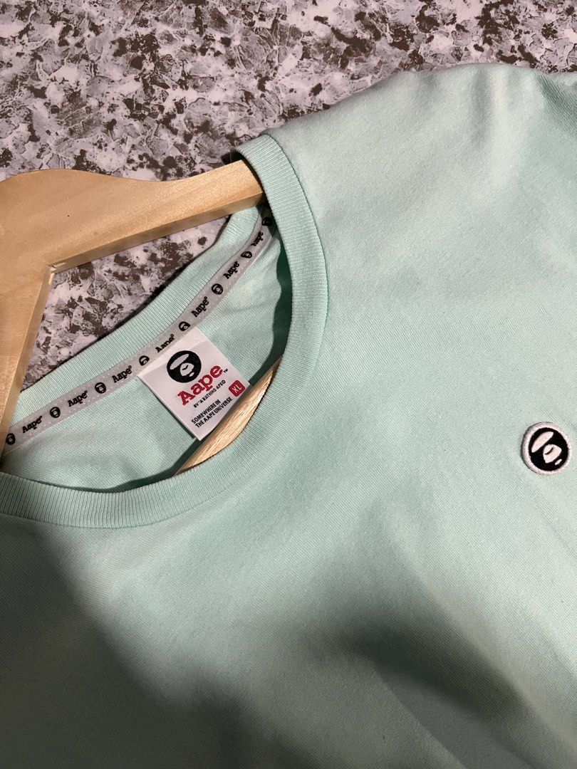 Aape By A Bathing Ape Mint Green T-Shirt (Category: Tshirts & Polo Shirts ) located in Maasin. Submitted by niconii090 (Listing ID 1468987316, Image 2). Description: - Brand: Aape by A Bathing Ape - Color: Mint Green - Size: XL - Material: 100% Cotton - Details: Embroidered chest monkey logo, branded sleeve tags, and Aape inner collar tape - Condition: Mint, with care tags attached.