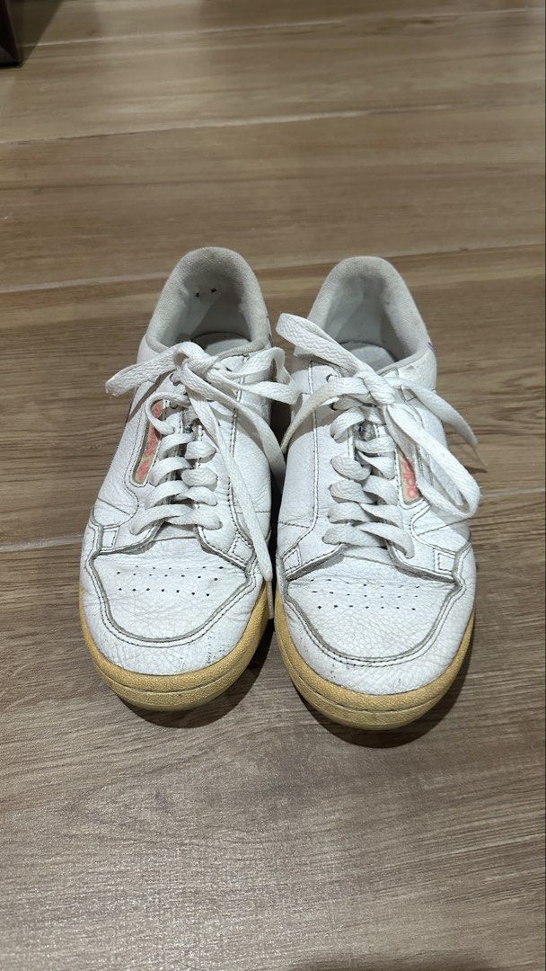 Adidas Continental 80 White Sneakers (Category: Sneakers) located in Pasig City. Submitted by nina.declutter (Listing ID 1468990321, Image 1). Description: - Brand: adidas - Color: White with pink branding, and blue/red piping - Material: Leather upper with white laces - Condition: Pre-loved with visible yellowing on soles, toe creasing, and scuffs - Interior: Normal dirt accumulation from regular use PLEASE MANAGE EXPECTATIONS, THIS IS OLD & USE