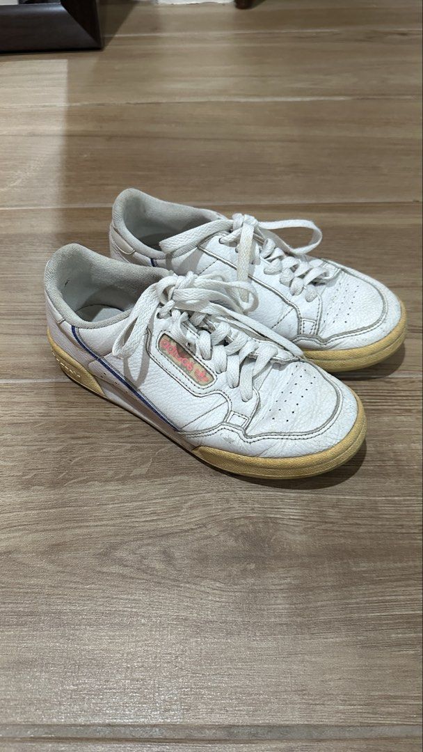 Adidas Continental 80 White Sneakers (Category: Sneakers) located in Pasig City. Submitted by nina.declutter (Listing ID 1468990321, Image 2). Description: - Brand: adidas - Color: White with pink branding, and blue/red piping - Material: Leather upper with white laces - Condition: Pre-loved with visible yellowing on soles, toe creasing, and scuffs - Interior: Normal dirt accumulation from regular use PLEASE MANAGE EXPECTATIONS, THIS IS OLD & USE