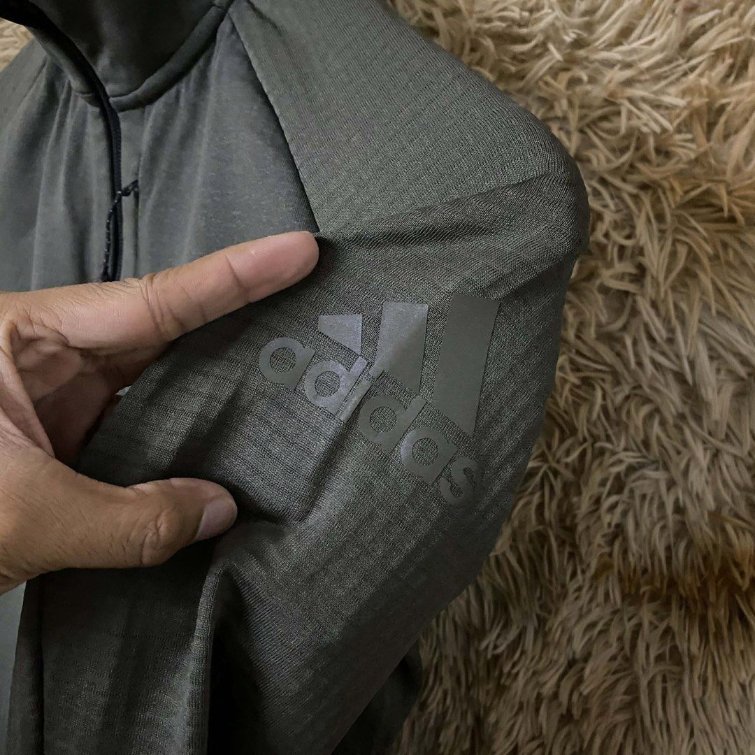 Adidas Dark Green Zip-Up Athletic Jacket (Category: Activewear) located in Butuan. Submitted by jc13thrifts (Listing ID 1469064030, Image 2). Description: - Color: Dark green - Design: Textured fabric panels, raglan sleeves, and subtle tonal Adidas logo on sleeve - Closure & Collar: Full zip closure with stand-up collar - Pockets: Two zippered side pockets plus a vertical chest pocket - Best for: Workouts, running errands, and cooler weather laye