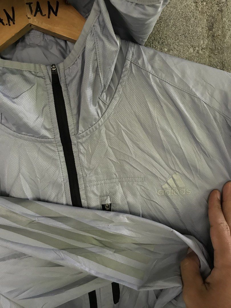 Adidas Grey Hooded Windbreaker Jacket Size L (Category: Coats, Jackets and Outerwear) located in Manila. Submitted by selme.finds (Listing ID 1468975005, Image 2). Description: - Brand: Adidas - Color: Grey - Size: Asia L (180/100A) - Material: Ribbed ripstop fabric - Features: Zip-up front, hood, and vertical zippered chest pocket - Style Code: GJ9949 - Production Date: 05/22 - Made in China - Condition: Excellent, ready to wear!.