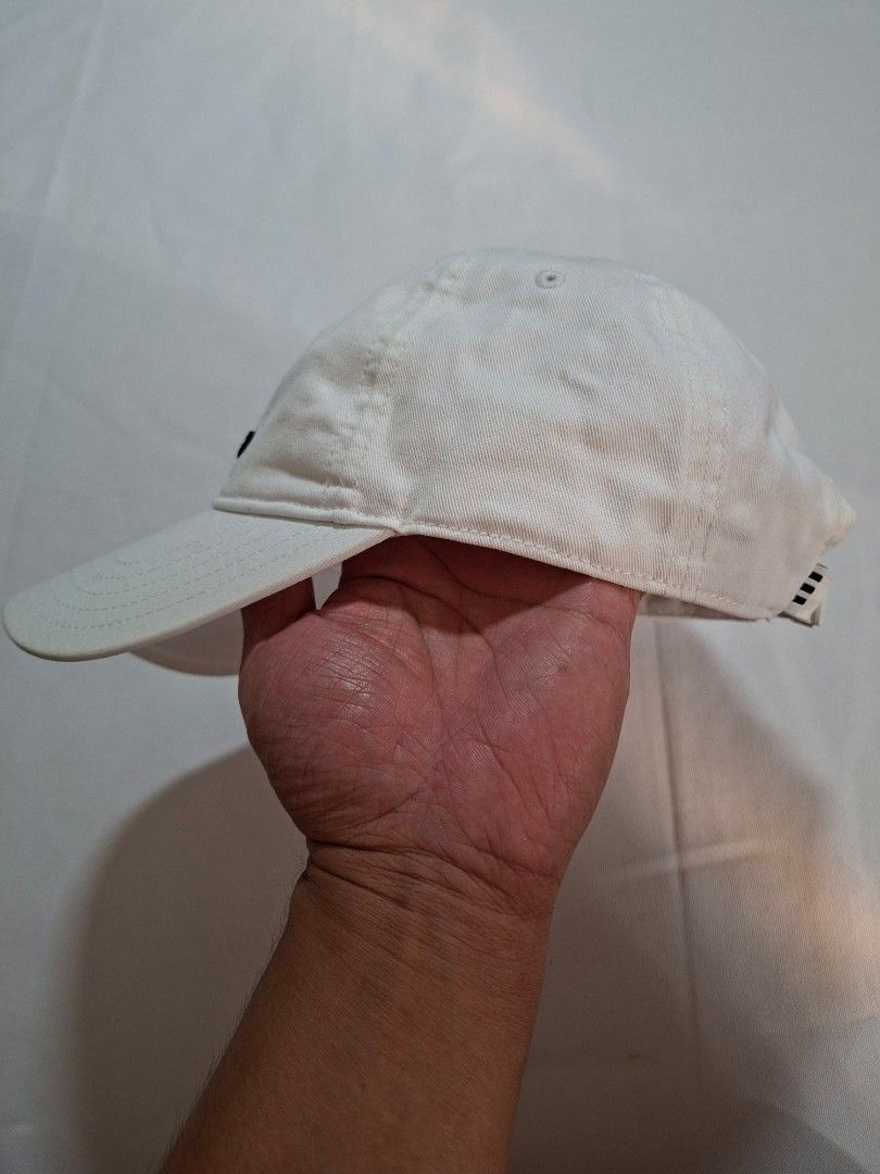 Adidas White Trefoil Baseball Cap (Category: Caps & Hats) located in Baguio. Submitted by restyrille77846 (Listing ID 1469065652, Image 3). Description: - Authentic Adidas baseball cap in classic white - Features iconic embroidered black trefoil logo on the front - Adjustable back strap with white metal buckle and subtle branding - Built-in ventilation eyelets for all-day breathability - Versatile design that matches any casual outfit.