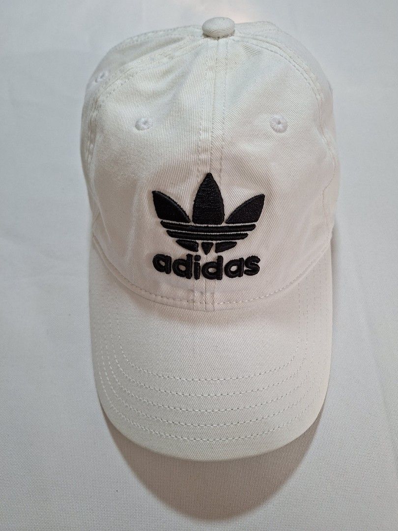 Adidas White Trefoil Baseball Cap (Category: Caps & Hats) located in Baguio. Submitted by restyrille77846 (Listing ID 1469065652, Image 1). Description: - Authentic Adidas baseball cap in classic white - Features iconic embroidered black trefoil logo on the front - Adjustable back strap with white metal buckle and subtle branding - Built-in ventilation eyelets for all-day breathability - Versatile design that matches any casual outfit.