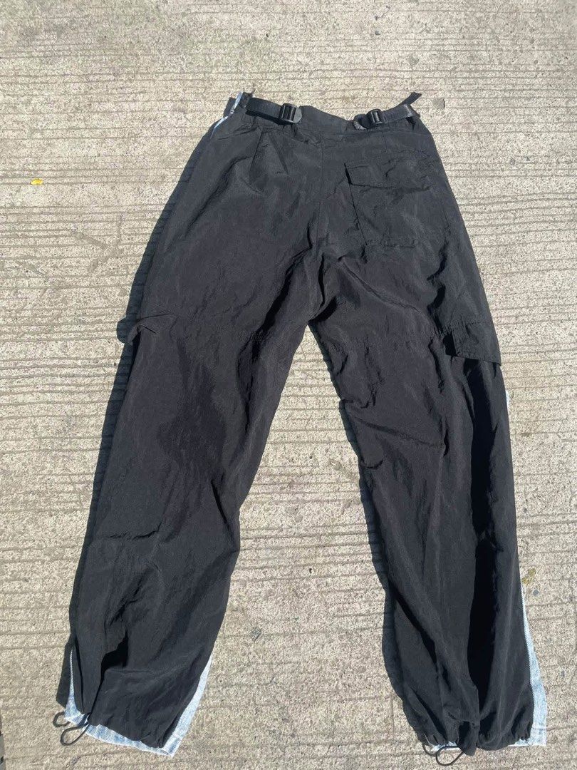 Alexander Wang denim and nylon cargo pants (Category: Jeans) located in Manila. Submitted by declutterwithme07 (Listing ID 1469024137, Image 2). Description: - Brand: Alexander Wang - Style: Hybrid cargo pants with a unique layered design - Material: Light wash denim front and black nylon back - Fit: Loose and relaxed streetwear fit - Features: Adjustable waist buckles, multiple cargo pockets, and drawstring hems - Authenticity: Label clearly vis