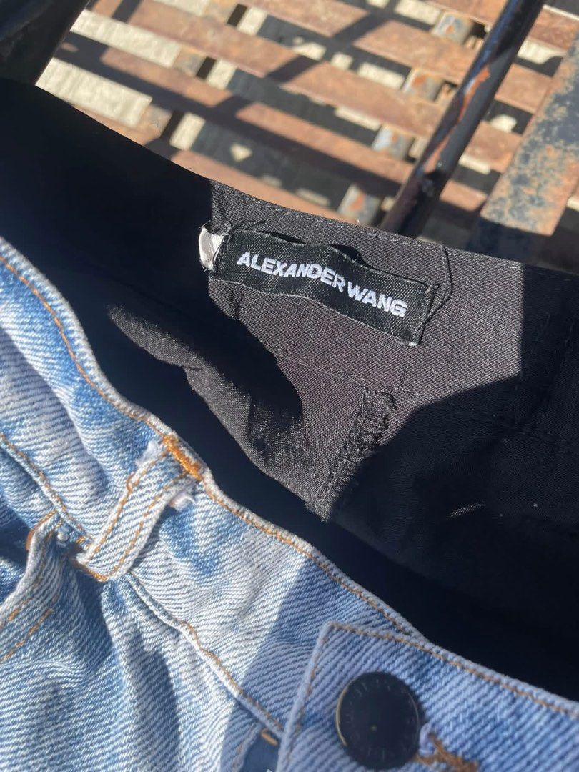 Alexander Wang denim and nylon cargo pants (Category: Jeans) located in Manila. Submitted by declutterwithme07 (Listing ID 1469024137, Image 3). Description: - Brand: Alexander Wang - Style: Hybrid cargo pants with a unique layered design - Material: Light wash denim front and black nylon back - Fit: Loose and relaxed streetwear fit - Features: Adjustable waist buckles, multiple cargo pockets, and drawstring hems - Authenticity: Label clearly vis