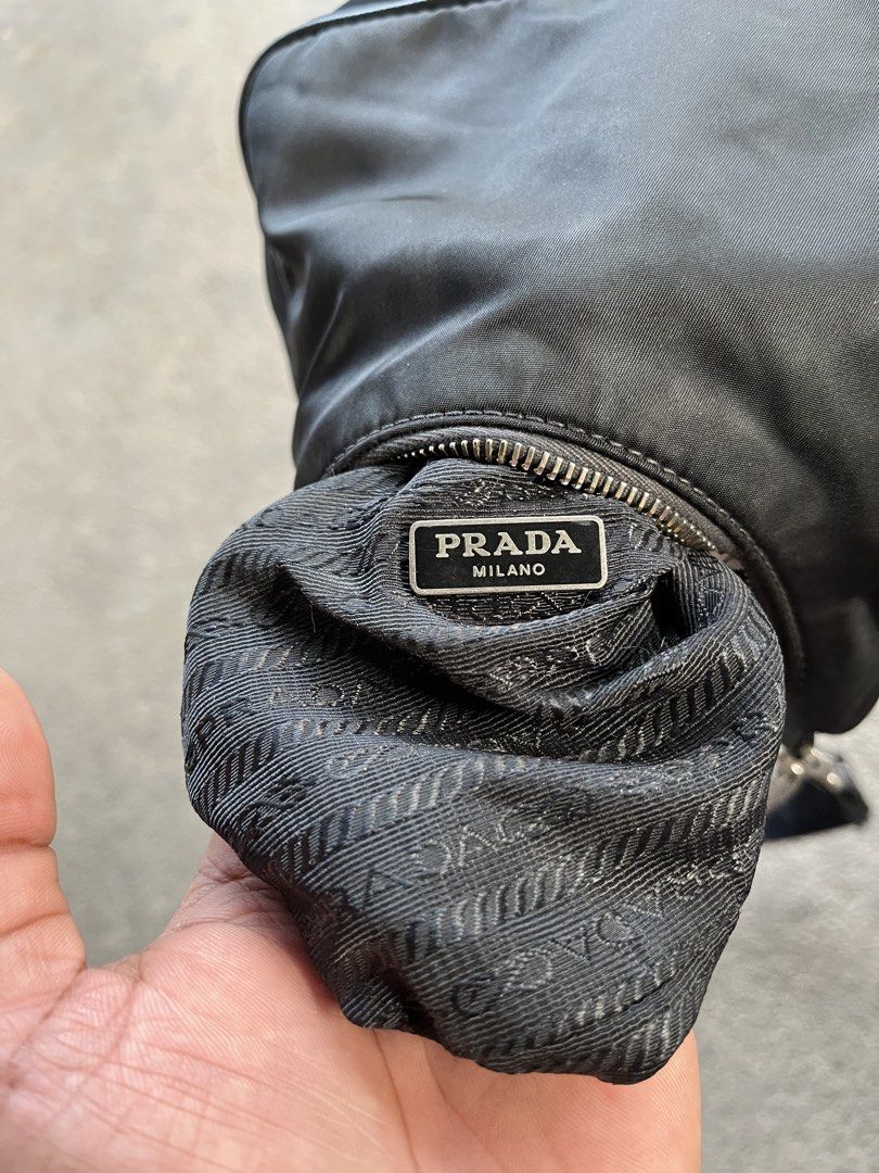 Authentic Prada Re-Edition Black Nylon Shoulder Bag (Category: Luxury Bags & Wallets) located in General Santos City (Dadiangas). Submitted by thiftnibadi3 (Listing ID 1469045616, Image 2). Description: - Authentic Prada shoulder bag in classic black nylon - Silver-tone hardware with stylish metal chain handle - Includes adjustable jacquard logo strap for versatile wear - Practical crescent shape that easily fits daily essentials - Interior featu