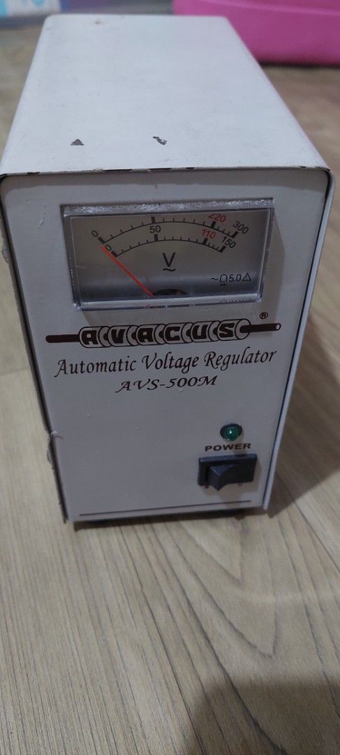 Avacus Automatic Voltage Regulator AVS-500M (Category: Electrical, Adaptors & Sockets) located in Taguig. Submitted by thrifthub.ph (Listing ID 1469077131, Image 2). Description: - Model: Avacus AVS-500M Automatic Voltage Regulator (AVR) - Output: Multiple 220V and 110V sockets on the back panel - Protection: Built-in 5A fuse cap for safety - Front Panel: Analog needle voltage meter, power switch, and indicator light - Condition: White metal casi