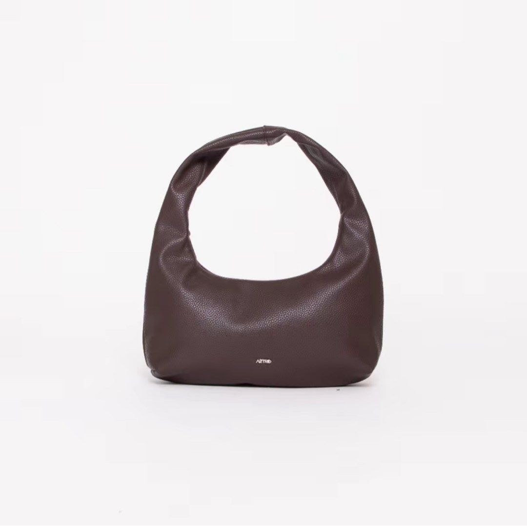 AZTRID Brown Small Hobo Bag (Category: Shoulder Bags) located in Batangas. Submitted by iiamkikay (Listing ID 1469061018, Image 1). Description: - Brand: AZTRID - Style: Small slouchy hobo bag in a versatile brown shade - Material: Pebble-textured faux leather with a clean, minimalist design - Hardware: Subtle silver logo on the front - Dimensions: Width 34 cm | Height 19 cm | Base 9 cm | Handle drop 7 cm - Capacity: Roomy enough to fit your phon
