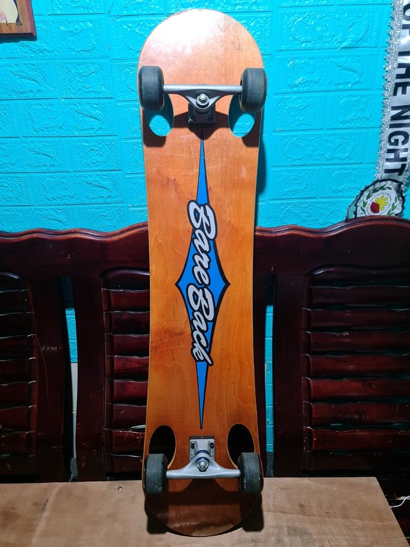Bare Back Skateboard with Green Wheels (Category: Skates, Rollerblades & Scooters) located in San Mateo. Submitted by gk2900504184839 (Listing ID 1468936498, Image 2). Description: - Brand: Bare Back complete skateboard (ready to ride) - Deck: Wooden deck with center wood stripe and black grip tape on top - Design: Blue graphic logo on a natural wood finish bottom - Hardware: Green wheels with black hubs and stylish purple bushings - Condition: M