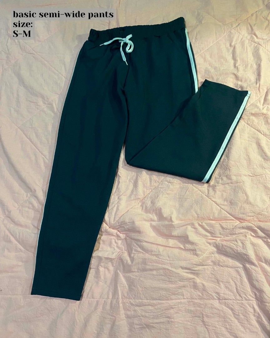 Basic semi-wide pants (Category: Jeans) located in Santa Cruz. Submitted by gelpcz (Listing ID 1469142122, Image 1). Description: - Color: Dark green with white side stripes - Fit: Comfortable fit for sizes S to M - Waist: Elastic waistband with matching white drawstring - Style: Casual semi-wide pants - Best for: Everyday lounging, running errands, or pairing with basic tees and hoodies.