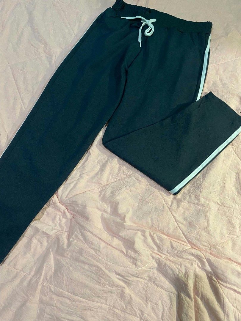 Basic semi-wide pants (Category: Jeans) located in Santa Cruz. Submitted by gelpcz (Listing ID 1469142122, Image 3). Description: - Color: Dark green with white side stripes - Fit: Comfortable fit for sizes S to M - Waist: Elastic waistband with matching white drawstring - Style: Casual semi-wide pants - Best for: Everyday lounging, running errands, or pairing with basic tees and hoodies.
