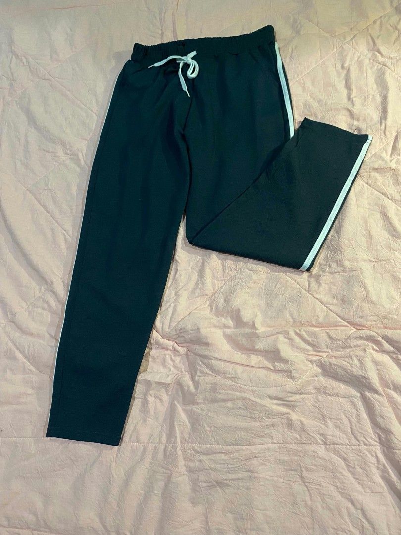 Basic semi-wide pants (Category: Jeans) located in Santa Cruz. Submitted by gelpcz (Listing ID 1469142122, Image 2). Description: - Color: Dark green with white side stripes - Fit: Comfortable fit for sizes S to M - Waist: Elastic waistband with matching white drawstring - Style: Casual semi-wide pants - Best for: Everyday lounging, running errands, or pairing with basic tees and hoodies.